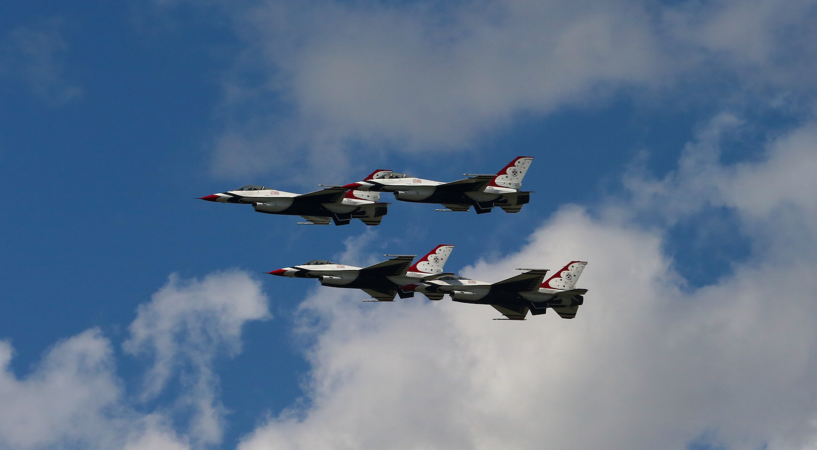 Air Force Thunderbird jets flying in close formation against blue sky