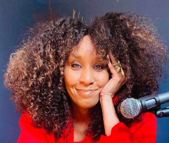 Nikki Thomas: smiling woman in red blouse with microphone