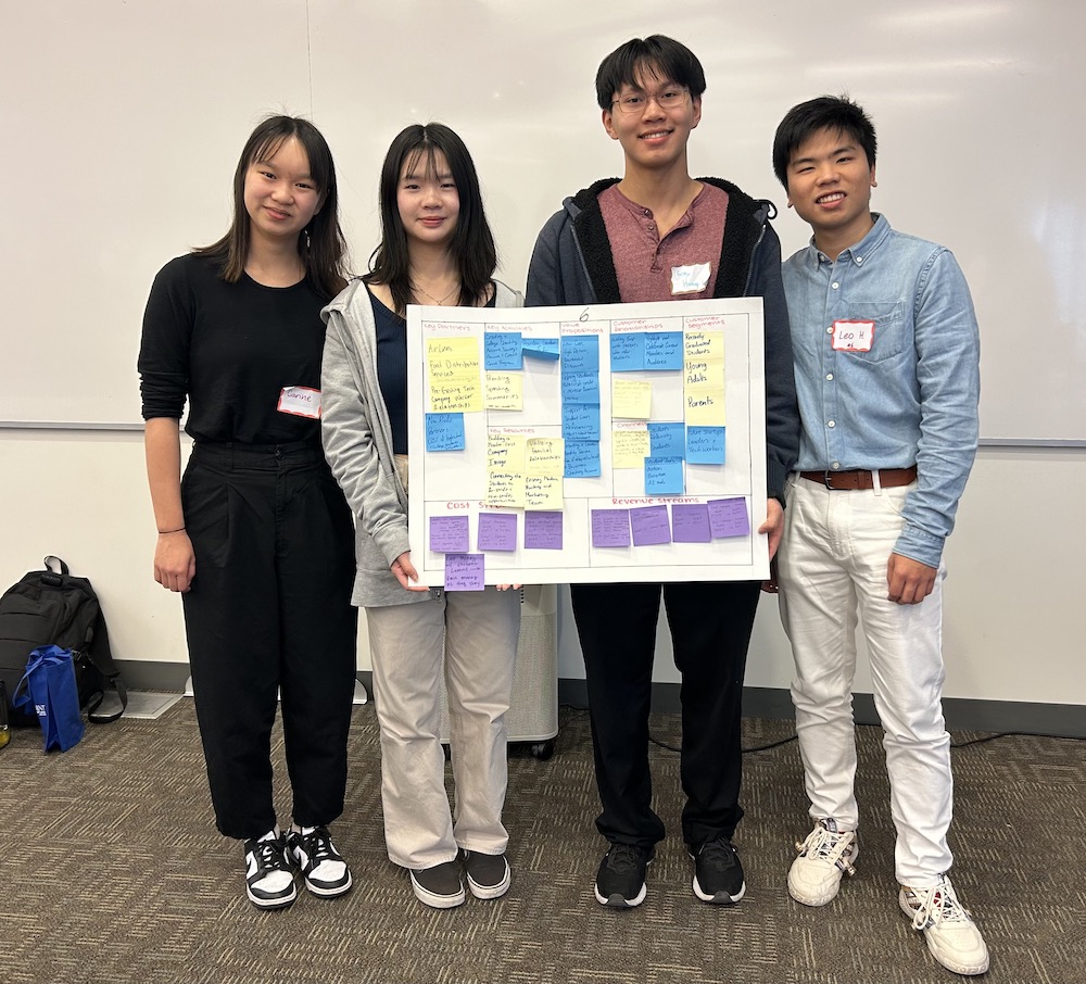 four students with poster