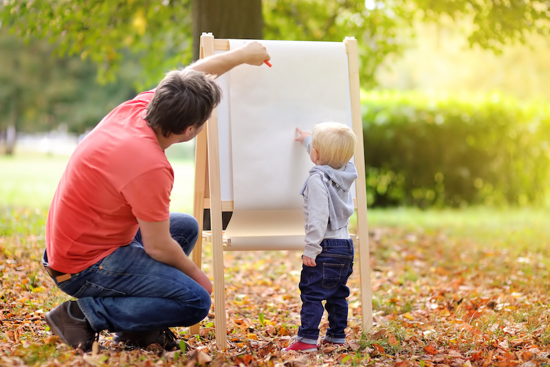 young man with child at easel