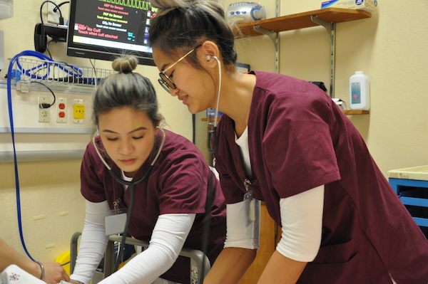 two nursing students attending a patient