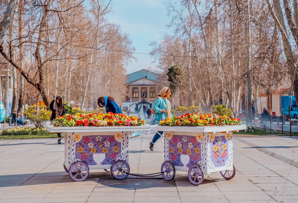 woman walking by flower cart