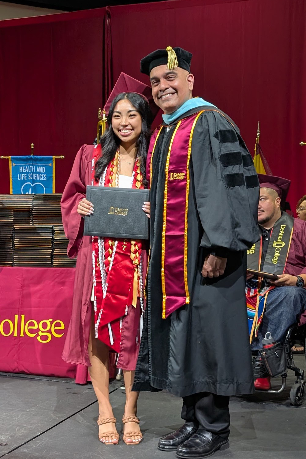 President Torres smiling with young woman in cap and gown