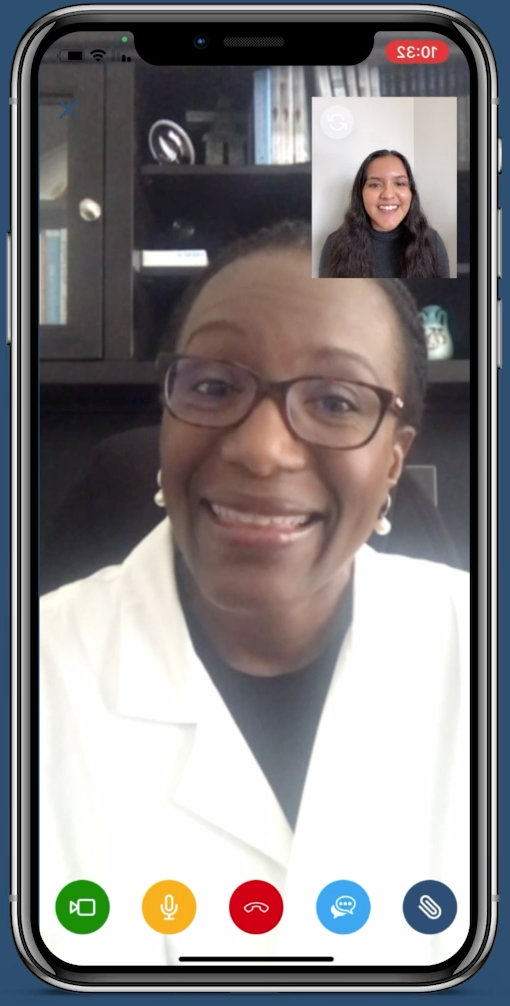 screenshot of woman in medical coat talking via smartphone video with young woman who is smiling