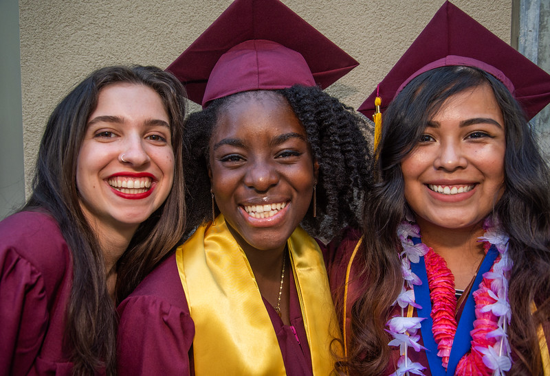 three young women in grad caps and gowns