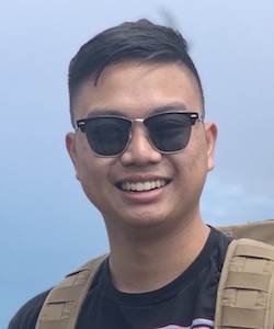Brandon Nguyen standing on hill with sunglasses